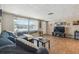 Cozy living room with wood floors, large window, comfortable sofa, and mounted television at 7830 Ilex Dr, Port Richey, FL 34668