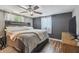Comfortable main bedroom featuring a ceiling fan, dark accent wall, and wood-look floors at 7830 Ilex Dr, Port Richey, FL 34668