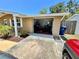 A detached garage with an open door displaying some items stored inside at 7861 Raintree Dr, New Port Richey, FL 34653