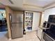 Kitchen area featuring stainless steel refrigerator and a large pantry for ample storage space at 7861 Raintree Dr, New Port Richey, FL 34653