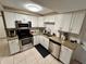Modern kitchen with stainless steel appliances, granite countertops, and ample cabinet space at 7861 Raintree Dr, New Port Richey, FL 34653