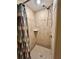 Tiled shower featuring a rainfall shower head and a convenient corner shelf at 7861 Raintree Dr, New Port Richey, FL 34653
