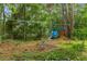 Backyard with a playground and climbing net between the trees in the background at 8102 Fort Dade Ave, Brooksville, FL 34601