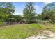 Large backyard showcasing a swing, flower beds, and plenty of room for outdoor activities at 8102 Fort Dade Ave, Brooksville, FL 34601