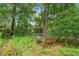 Wood bench and fire place with a trampoline hidden in the background of a large private backyard at 8102 Fort Dade Ave, Brooksville, FL 34601