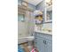 Bathroom with a tub, shower, gray vanity and open shelving for storage at 8102 Fort Dade Ave, Brooksville, FL 34601