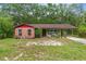 Charming single-story home with brick accents, a cozy carport, and lush greenery in a serene setting at 8102 Fort Dade Ave, Brooksville, FL 34601