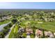 An aerial view shows a golf course community with lush greenery, serene water features and single Gathering homes at 8132 Summersong Ct, Spring Hill, FL 34606