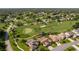 Expansive aerial view showcasing a neighborhood with a golf course and mature landscaping at 8132 Summersong Ct, Spring Hill, FL 34606