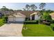 Aerial view of the house highlighting the well-manicured lawn and paved driveway at 8132 Summersong Ct, Spring Hill, FL 34606