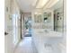 Bright bathroom with white cabinets, tiled floor, and a view of the pool area at 8132 Summersong Ct, Spring Hill, FL 34606