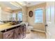 Bathroom with a unique stone sink on a wooden vanity, tiled floors, and a walk-in shower at 8132 Summersong Ct, Spring Hill, FL 34606