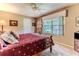 Cozy bedroom with a ceiling fan, a large window, and neutral colored walls at 8132 Summersong Ct, Spring Hill, FL 34606