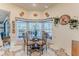 Bright breakfast nook with a decorative tiled floor, surrounded by windows and a glass top table at 8132 Summersong Ct, Spring Hill, FL 34606