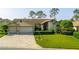 Charming single story home with a manicured lawn, paved driveway, and three-car garage at 8132 Summersong Ct, Spring Hill, FL 34606