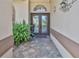 Front door with decorative glass, a tiled entryway, and updated exterior lighting at 8132 Summersong Ct, Spring Hill, FL 34606