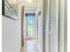 Bright hallway with hardwood floors, closet doors, and a view of the backyard at 8132 Summersong Ct, Spring Hill, FL 34606