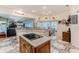 Open kitchen with decorative tiled floor, central island, and eating area with bay windows at 8132 Summersong Ct, Spring Hill, FL 34606