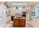 Spacious kitchen with white cabinets, a central island with cooktop and black appliances at 8132 Summersong Ct, Spring Hill, FL 34606