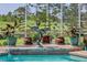 A water feature is surrounded by lush plants and a screened-in lanai in this backyard at 8132 Summersong Ct, Spring Hill, FL 34606