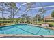 Screened in swimming pool, featuring a brick surround, surrounded by well-maintained landscaping at 8132 Summersong Ct, Spring Hill, FL 34606