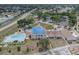 Aerial view of community center with pool, tennis courts, and parking, offering residents various amenities at 8228 Coral Creek Loop, Hudson, FL 34667