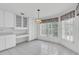 Bright dining area with a pendant light fixture, large windows, and white tile flooring at 8228 Coral Creek Loop, Hudson, FL 34667