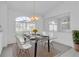Elegant dining room with a glass-top table, modern chairs, and large window for natural light at 8228 Coral Creek Loop, Hudson, FL 34667