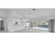 Open living space with white walls, offering seamless access to the pool area via sliding glass doors at 8228 Coral Creek Loop, Hudson, FL 34667
