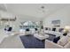 Inviting living room features stylish white sofas, a blue rug, and a view of the pool area at 8228 Coral Creek Loop, Hudson, FL 34667
