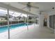 Enclosed pool area with fans, offers a private outdoor retreat with access to the backyard and pool at 8228 Coral Creek Loop, Hudson, FL 34667