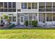 Exterior view showcasing the backyard with lush lawn, foliage, and the building's rear facade at 8405 112Th St # 103, Seminole, FL 33772