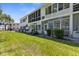 Exterior view showcasing the backyard with lush lawn and foliage, and the building's rear facade at 8405 112Th St # 103, Seminole, FL 33772