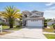 Two-story home with a white garage door, a palm tree, and well-maintained lawn at 8526 Hawbuck St, Trinity, FL 34655