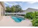 Backyard swimming pool with a well-kept white fence and beautiful green landscaping at 8526 Hawbuck St, Trinity, FL 34655