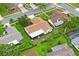 Drone shot of the home, highlighting its roof, screened enclosure, and verdant backyard at 8700 Wind Mill Dr, New Port Richey, FL 34655