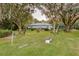 Beautiful backyard with lush lawn, seating area, and mature trees at 8700 Wind Mill Dr, New Port Richey, FL 34655