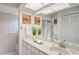 Bathroom featuring a white vanity, a large mirror, and a glass-enclosed shower at 8700 Wind Mill Dr, New Port Richey, FL 34655