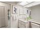 Bright bathroom featuring a vanity, framed art, and an accessible passageway at 8700 Wind Mill Dr, New Port Richey, FL 34655