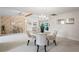 Open concept dining room with a glass table, chandelier, and neutral wall decor at 8700 Wind Mill Dr, New Port Richey, FL 34655