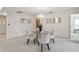 Stylish dining room featuring a round glass table with seating for four, with views into the living room at 8700 Wind Mill Dr, New Port Richey, FL 34655