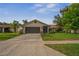 Charming single-story home features a well-manicured lawn, a driveway, and attached garage at 8700 Wind Mill Dr, New Port Richey, FL 34655