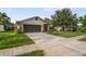 Charming single-story home features a well-manicured lawn, a driveway, and attached garage at 8700 Wind Mill Dr, New Port Richey, FL 34655