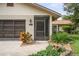 Close-up view of the home's front door and garage showcasing the detailed landscaping at 8700 Wind Mill Dr, New Port Richey, FL 34655