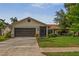 Inviting home featuring an attached garage, screened entry, and neatly manicured front lawn at 8700 Wind Mill Dr, New Port Richey, FL 34655