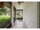 Long view of front porch with tile flooring, a ceiling fan, and a view of the neighborhood at 8700 Wind Mill Dr, New Port Richey, FL 34655