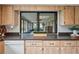 Kitchen counter with a window view into a sunroom, featuring wooden cabinets and tile countertops at 8700 Wind Mill Dr, New Port Richey, FL 34655