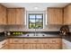 Kitchen showcasing wooden cabinets, stainless steel sink, and a window overlooking the backyard at 8700 Wind Mill Dr, New Port Richey, FL 34655
