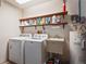 Functional laundry area equipped with a washer, dryer, and storage shelves for organization at 8700 Wind Mill Dr, New Port Richey, FL 34655