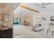 Bright living room featuring a vaulted ceiling with wooden beams, light beige carpet, and sliding glass doors at 8700 Wind Mill Dr, New Port Richey, FL 34655